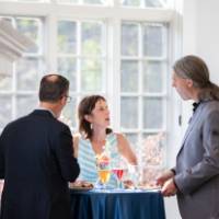 faculty talking at a high-top table